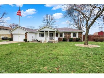 Charming single-story home featuring a well-manicured lawn and an inviting front porch with white railings at 6958 W Brier Creek Dr, New Palestine, IN 46163