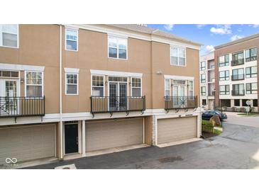 Two-story condo featuring private garage, balcony, and neutral-toned exterior at 907 Junction Pl # 41907, Indianapolis, IN 46220