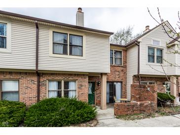 Attractive townhome featuring a brick facade, vinyl siding, and a cozy front patio at 9449 Maple Way, Indianapolis, IN 46268