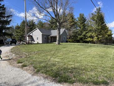 Charming single-story home featuring a well-maintained lawn, mature trees, and cozy front porch at 17245 N 200 E, Summitville, IN 46070