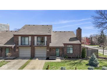Charming brick townhouse with attached garage, balcony and well-manicured lawn at 310 E St Clair St, Indianapolis, IN 46202