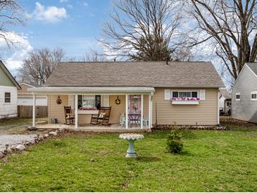 Charming single-story home with a covered front porch, flower boxes, and mature trees at 509 W Pierson St, Greenfield, IN 46140