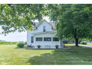 White farmhouse with covered front porch, stone surround, and mature trees at 6045 N 300 W, Greenfield, IN 46140