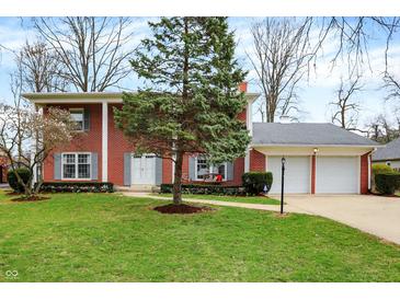 Charming two-story brick home with a well-maintained front yard and an attached two-car garage at 6537 Grosvenor Pl, Indianapolis, IN 46220