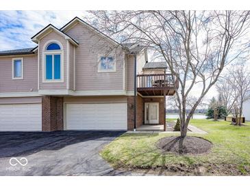 Charming townhouse with a two-car garage, balcony, and manicured front lawn at 7653 River Rd, Indianapolis, IN 46240
