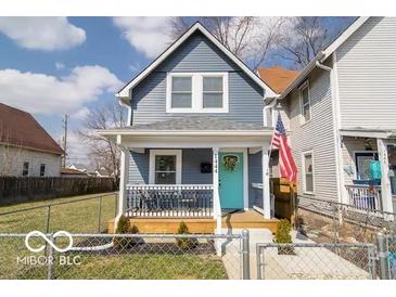 Charming two-story home featuring a welcoming front porch and a vibrant turquoise front door at 1444 English Ave, Indianapolis, IN 46201