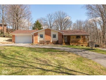 Charming home featuring brick accents, a covered porch, a lawn, and an attached garage at 251 Howard Rd, Greenwood, IN 46142