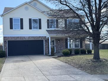 Two-story home with a brick and vinyl exterior and a two-car garage and a well manicured lawn at 6417 E Clarks Hill Ct, Camby, IN 46113