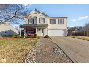 Charming two-story home with a front porch swing and well-manicured lawn with brick walkway at 76 Wyndham Ln, Brownsburg, IN 46112