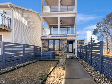 Modern three-story home showcasing multiple balconies, stone accents and a stylish privacy fence at 917 Buchanan St, Indianapolis, IN 46203