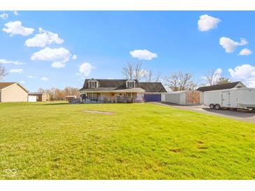 Charming two-story home with a large lawn and covered porch, featuring multiple outbuildings at 1243 S Morristown Pike, Greenfield, IN 46140