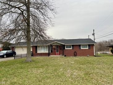 Charming single-story brick home featuring a well-maintained lawn and a classic red front door at 128 Mulberry Rd, Anderson, IN 46017