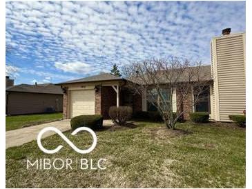 Charming single-story home with a well-maintained lawn and attached garage at 1836 Queensbridge N Cir, Indianapolis, IN 46219