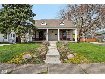 Charming single-story home featuring a welcoming front porch with red doors at 304 W 43Rd St, Indianapolis, IN 46208
