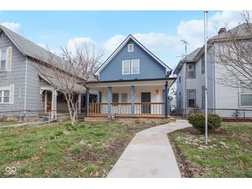 Charming blue two-story home with inviting front porch and well-maintained lawn at 324 W 7Th St, Anderson, IN 46016