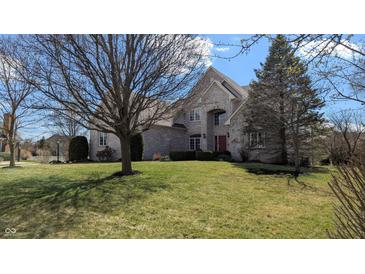 Charming two-story home with brick exterior, well-manicured lawn, and mature trees at 452 Twin Oaks Dr, Carmel, IN 46032