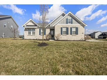 Inviting single-story brick home featuring a manicured lawn and classic architectural details at 6672 Eagles Nest Ln, McCordsville, IN 46055