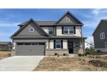 Charming two-story home featuring a two-car garage and a mix of siding and brick accents at 8893 Alexander Ridge Dr, McCordsville, IN 46055