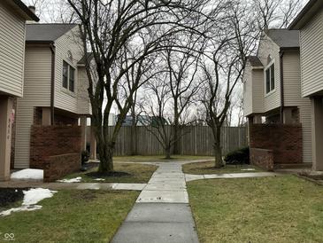 Exterior view of townhomes with sidewalk leading to a central courtyard and bare trees at 9452 Maple Way, Indianapolis, IN 46268