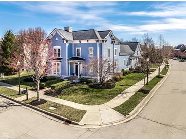 Charming blue two-story home with manicured landscaping and inviting curb appeal in a suburban neighborhood at 12895 Grenville St, Carmel, IN 46032