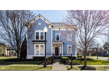 Charming blue two-story home with manicured lawn, brick walkway and an inviting front porch at 12895 Grenville St, Carmel, IN 46032
