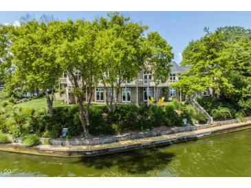 Waterfront home featuring a lakeside view, outdoor seating, mature trees, and a multi-tiered deck at 1326 White Water Ct, Cicero, IN 46034