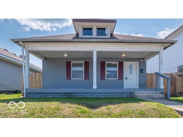 Charming single-story home featuring a cozy front porch and light blue siding, perfect for relaxed living at 1327 E Minnesota St, Indianapolis, IN 46203