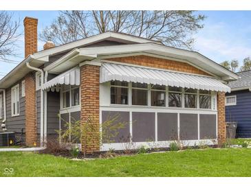 Charming sunroom features awning, brick accents, and ample natural light at 5226 E St Clair St, Indianapolis, IN 46219