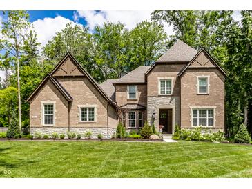 Beautiful brick two-story home with a well-manicured lawn and professionally landscaped front yard at 552 E 82Nd St, Indianapolis, IN 46240