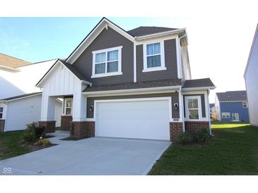 Charming two-story home featuring a two-car garage, gray siding, white trim, and a well-manicured lawn at 735 Locust Dr, Danville, IN 46122