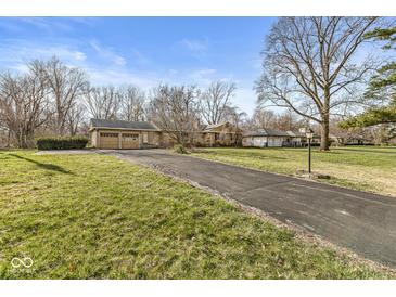 Asphalt driveway of a single-story home leading to a two-car garage on a grassy lot at 8606 Manderley Dr, Indianapolis, IN 46240