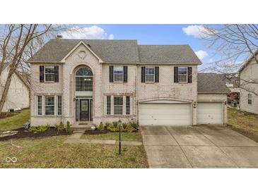 Charming two-story home with a three-car garage and brick exterior, enhanced by a well-manicured lawn at 11046 Timberview Dr, Fishers, IN 46037