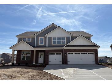 Two-story home featuring a two-car garage, brick accents, and gray siding under a blue sky at 1260 Thornwood Dr, Greenwood, IN 46143