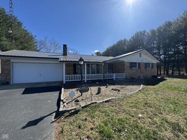 Charming brick home featuring an attached garage, cozy porch, and well-maintained front yard landscaping at 2115 Leonard Rd, Martinsville, IN 46151