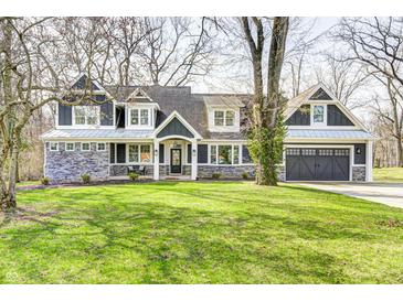 Charming two-story home featuring stone accents, gray siding, and a well-manicured lawn at 4915 E 79Th St, Indianapolis, IN 46250
