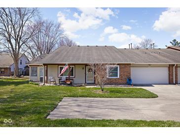 Charming single story home featuring an attached two car garage and a well maintained front yard at 7349 Castleton Farms N Dr, Indianapolis, IN 46256
