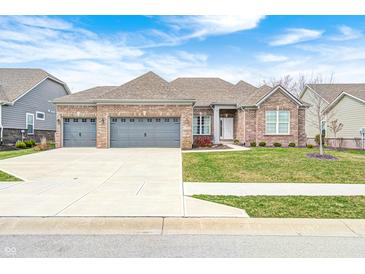 Charming brick home featuring a three-car garage, well-manicured lawn, and inviting curb appeal at 11598 Platt St, Noblesville, IN 46060