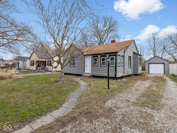 Quaint single-Gathering home with gray siding, brown roof, and detached garage at 1241 Brandt Dr, Indianapolis, IN 46241