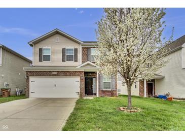 Charming two-story home with brick and vinyl siding, featuring a well-manicured lawn and blooming tree at 2468 Shadow Bend Dr, Columbus, IN 47201
