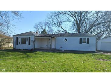 Exterior of a single-story home with an attached garage, front lawn and large trees at 318 Chester St, Anderson, IN 46012