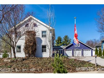 Charming two-story home with a gravel driveway and detached garage with a 'For Sale' flag at 3926 Rookwood Ave, Indianapolis, IN 46208