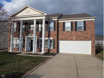Traditional two-story brick home with white columns, two-car garage, and manicured front lawn at 5565 Noble Dr, Indianapolis, IN 46234