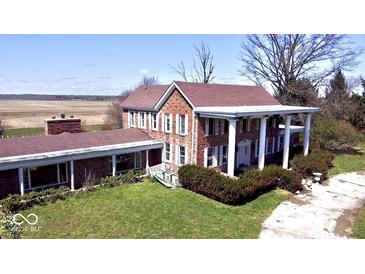 An exterior view showing the red brick, columned front, and landscaped lawn at 7180 N State Road 42, Eminence, IN 46125
