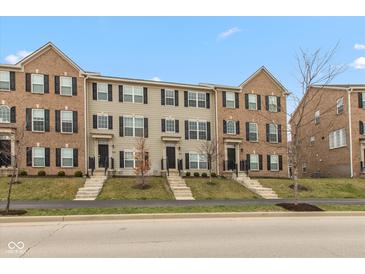 Charming townhomes featuring brick and vinyl exteriors, complemented by manicured lawns and inviting front entrances at 7247 Barker St, Carmel, IN 46033