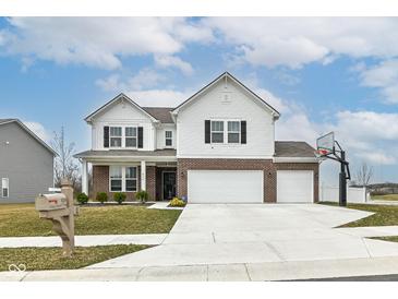 Inviting two-story home with brick accents, three-car garage, basketball hoop, and a manicured lawn at 836 Grassy Branch Dr, Indianapolis, IN 46239