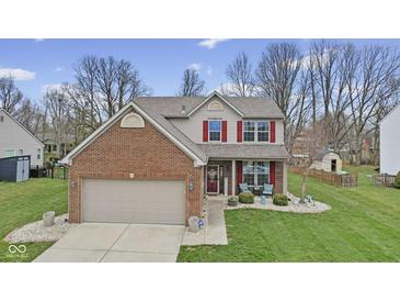 Charming two-story home featuring a brick facade, red shutters, manicured lawn, and attached two-car garage at 894 Woodgate Ln, Greenwood, IN 46143
