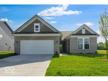 Charming single-story home with a two-car garage, well-maintained lawn, and neutral brick facade at 1023 Grassy Br Dr, Indianapolis, IN 46239