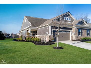 Charming home featuring a two-car garage, well-manicured lawn and tasteful landscaping under a clear sky at 17346 Haxby Ln, Westfield, IN 46074