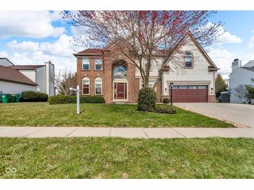 Charming brick two-story home boasts a lush lawn and a two-car garage at 250 W Tansey Crossing, Westfield, IN 46074