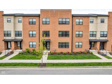 Modern brick townhomes featuring well-manicured lawns, a walkway, and large windows at 2578 Filson St, Carmel, IN 46032